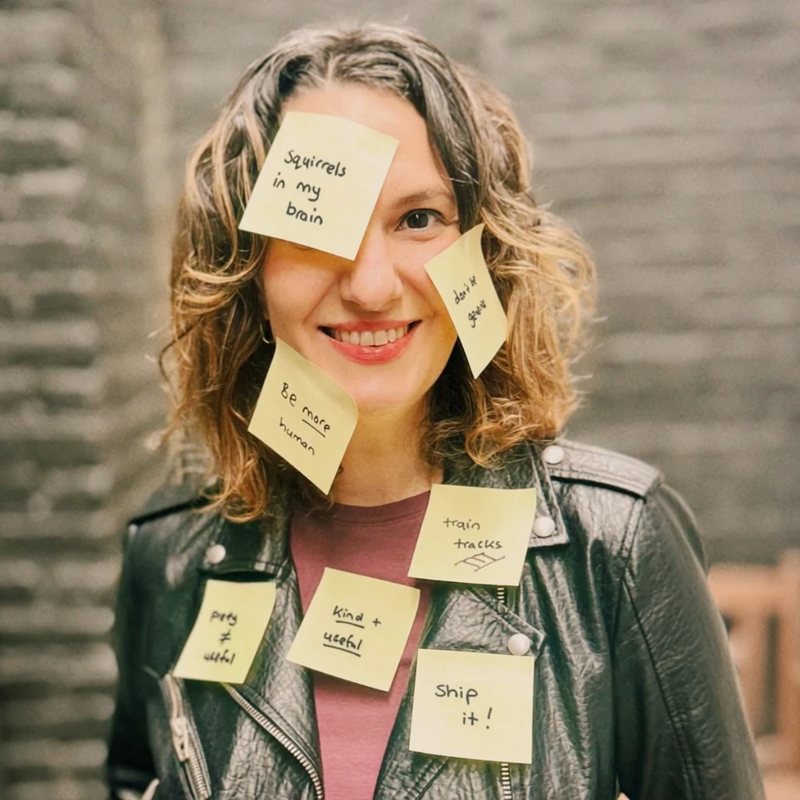 Zeina Muna with sticky notes on her face and jacket reading 'squirrels in my brain', 'be more human', 'train tracks' and 'ship it!'